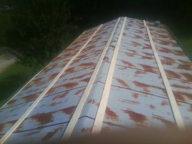 Rusted metal roof panels with new wood purlins before replacement — Storm Damage Roof Repair in Lawsonville by Roofing Brothers