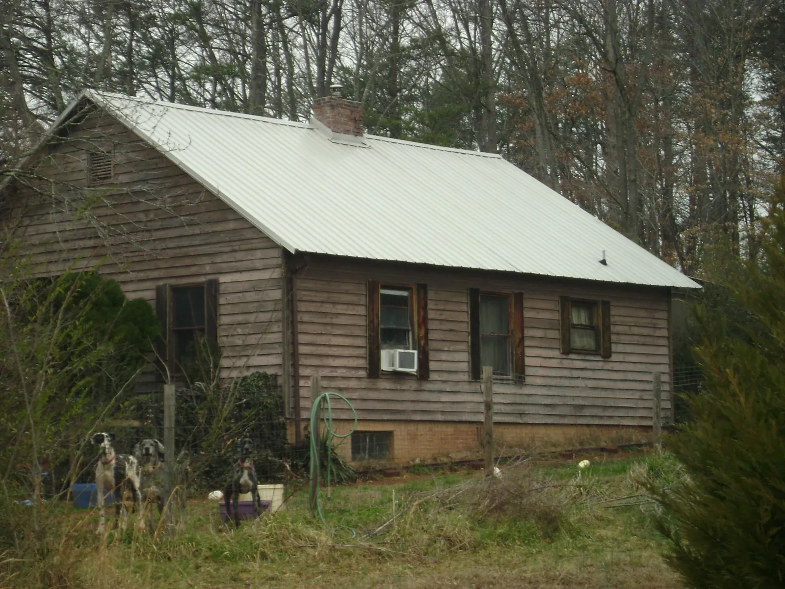 White metal roof on an old wood sided farmhouse, from a Asphalt Shingle Roof Repair job in Lawsonville